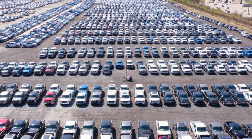 In 2001, a parking lot sits full of pickup trucks awaiting microchips to help them run.